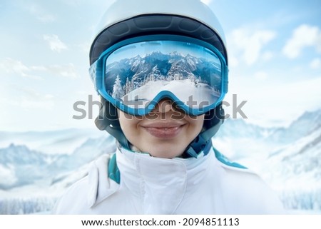 Woman At The Ski Resort On The Background Of Mountains And Blue Sky.A Mountain Range Reflected In The Ski Mask. Winter Sports.