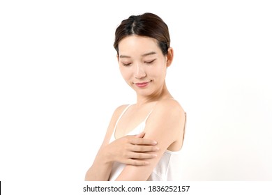 A woman with a skin care image that touches her arm
