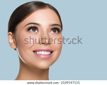 Woman skin face with lashes beautiful eyes healthy hair brunette. Look up. Color background.