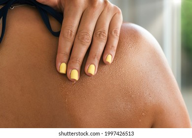 Woman skin shoulder with waterdrops and mist on a hot summer day