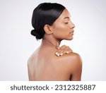 Woman, skincare and relaxed with back in studio for wellness, healthy glow and self care by white background. Indian model girl, skin health and soft touch with cosmetics, thinking and aesthetic