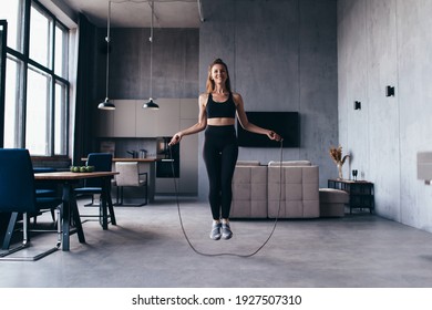 Woman skipping with jump rope at home.