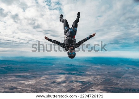 woman skydiver alone in cloudy skies over the desert