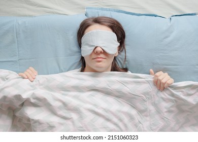woman in a sleep mask is lying in bed and sleeping. a happy European woman with mental health and sound sleep or with sleep problems and insomnia falling asleep in a cozy house. sleep disorders or