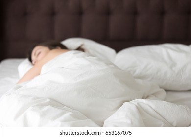 Woman Sleeping Alone On Large Double Bed. Lady Resting In Bedroom Early In The Morning, Enjoys Long Sleep On Day Off, Relaxing After Hard Work Day, Luxuriates In Bed, Recovering After Restless Night 