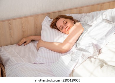 Woman Sleeping In Bed At Home. Deep Restful Sleep. Lady With Long Brown Hair Wearing A Nightgown. High Angle View Girl Lying In A Nightie On Clean White Bed Linen With Cozy Blanket.