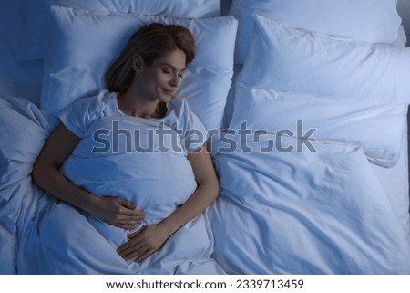 Woman sleeping in bed at night, above view. Space for text