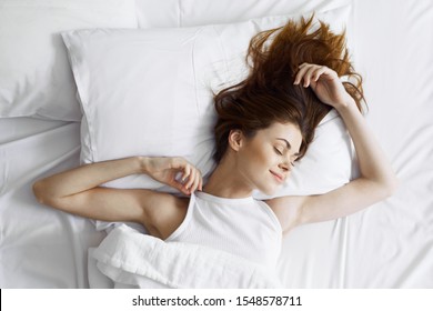 Woman Sleeping In Bed Under A Blanket Top View