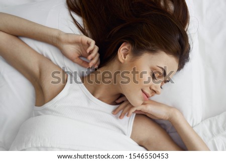 Woman sleeping in bed under a blanket top view