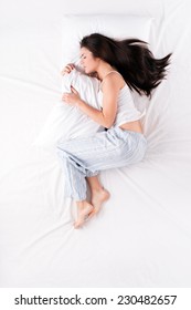 Woman Sleeping In Fetal Position With Pillow