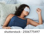 Woman, sleeping mask and relax in bedroom for peace, calm and home for recovery on weekend. Female person, pillow and bed for resting in apartment, dream nap and comfortable fatigue for wellness