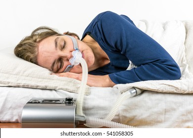 Woman Sleeping On Her Side With CPAP Machine In The Foreground, Sleep Apnea Treatment.