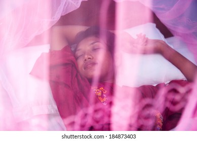 Woman Sleeping Under A Mosquito Net