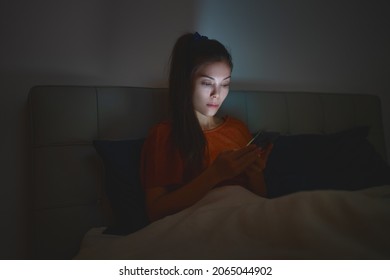 Woman Sleeping Using Phone In Bed Staying Up Late At Night Reducing Her Sleep Time Which Is Bad For Mental Health And Depression.