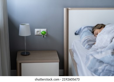 Woman Sleeps Next To An Electric Fumigator In A Socket To Protect Against Biting Insects, Selective Soft Focus. Domestic Electric Raptor Fumigator For Mosquitoes Protection At Home. 