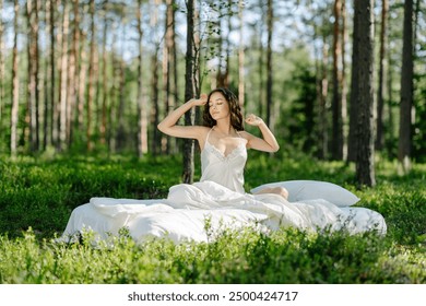 Woman sleeps on a mattress in the summer forest. Girl wakes up in a summer forest - Powered by Shutterstock