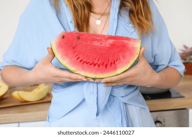 Woman with slice of fresh watermelon at kitchen, closeup - Powered by Shutterstock