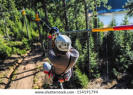 Woman sliding on a zip line in an adventure park