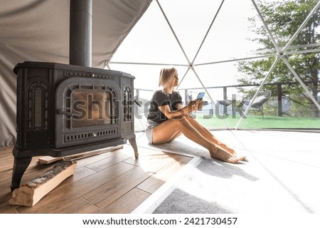 woman with smartphone in dome tent