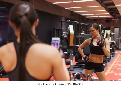 Woman With Smartphone Taking Mirror Selfie In Gym