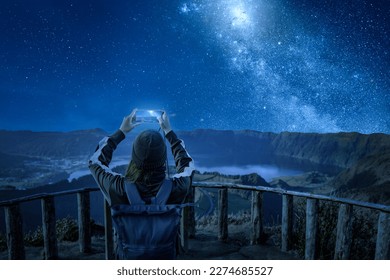 Woman with a smartphone under a starry night sky - Powered by Shutterstock