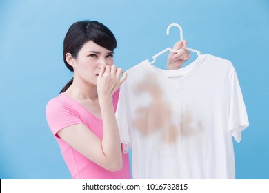 Woman Smell Bad With Dirty Shirt On The Blue Background