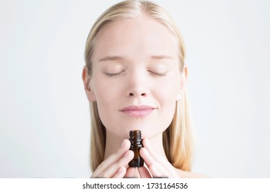 Woman Smelling A Bottle Of Essential Oil. Aromatherapy.