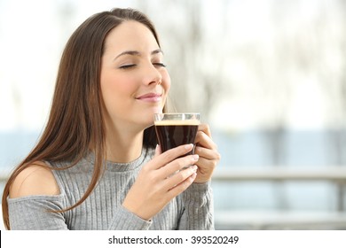 Woman Smelling Coffee Aroma In A Transparent Cup In A Terrace With The Sea In The Background