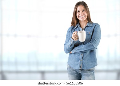 Woman Smelling A Cup Of Coffee, Ready To Drink It In An Office