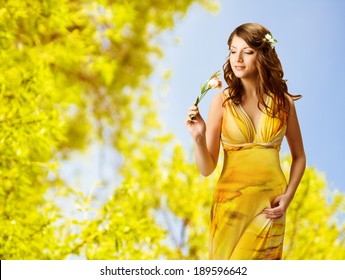 Woman Smelling Flowers, Spring Portrait Of Beautiful Girl In Yellow Dress