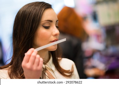Woman smelling a perfume tester in a shop