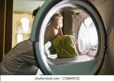 Woman Smells Of Clean Laundry Fresh From The Washing Machine After Washing