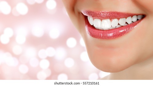 Woman smile closeup against an abstract background with blurred lights