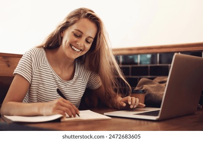 Woman, smile and writing at cafe with laptop as university student for elearning or online education. Female learner, happy and satisfied with studying or revision and research for college exams - Powered by Shutterstock