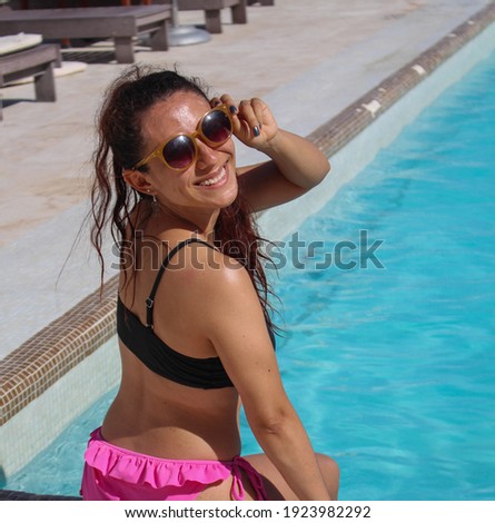 Brunette surfer woman with top and bikini holding surfboard