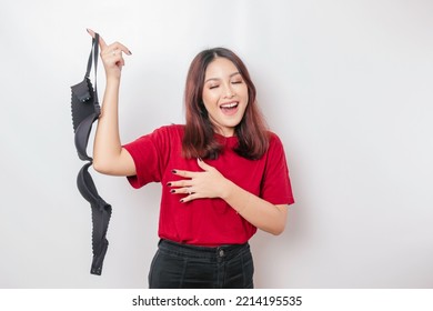 Woman smiling and holding a bra against white background. Concept of Breast cancer awareness and international no bra day celebration