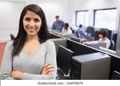 Woman smiling and standing in the front of the computer class - Powered by Shutterstock