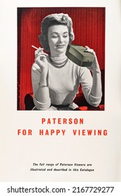 WOMAN SMOKING 1950s 1960s ADVERTISEMENT Plymouth Devon UK June 15th 2022 Vintage Retro Advert Showing Woman Holding Cigarette With Paterson Photograph Slide Viewer. Depiction Of Women In Advertising