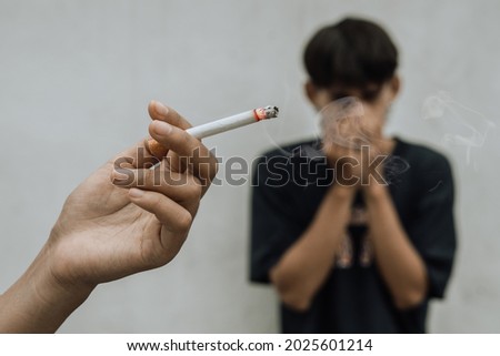 Woman smoking cigarette near people in public,smelling pollution,passive smoking concept