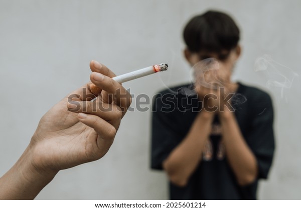 Woman smoking cigarette near people in\
public,smelling pollution,passive smoking\
concept
