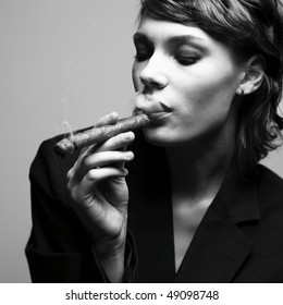 Woman Smoking Cigars. Studio Fashion Photo