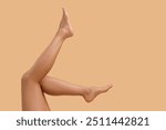 Woman with smooth legs on beige background, closeup. Space for text