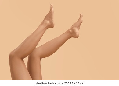 Woman with smooth legs on beige background, closeup. Space for text