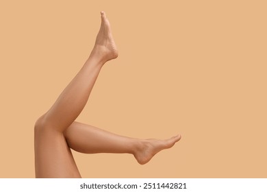 Woman with smooth legs on beige background, closeup. Space for text