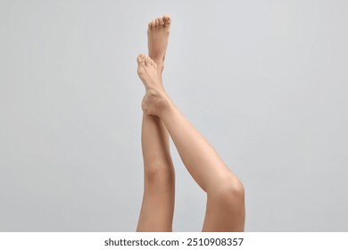 Woman with smooth legs on grey background, closeup