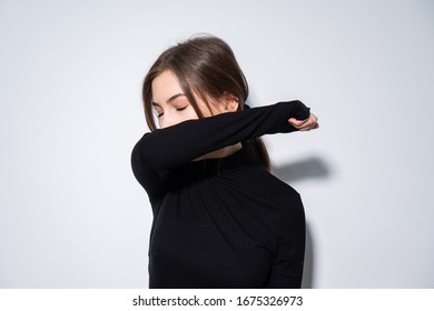 Woman Sneezing In Elbow Wearing Black 