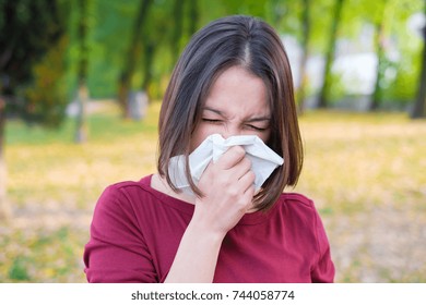 Woman Sneezing In A Kleenex Because Of Seasonal Allergy