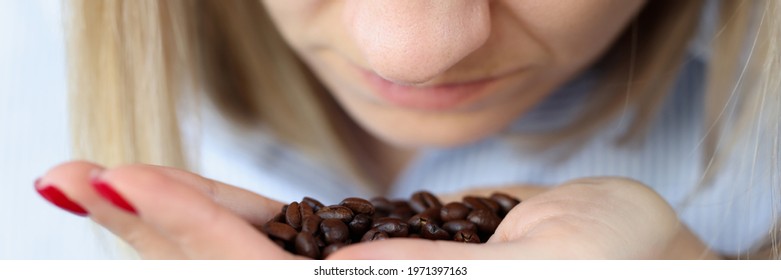 Woman Is Sniffing Coffee Grains On Her Palm