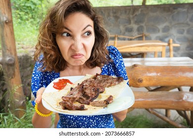 Woman Sniffs A Spoiled Steak In A Restaurant. The Concept Of Suffering From Anorexia Or An Eating Disorder And Loss Of Sense Of Smell After Covid.