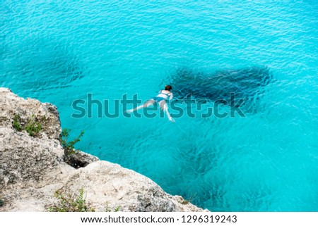 Woman snorkeling in blue water, Curacao